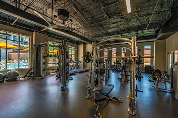 A gym with a variety of equipment including treadmills, weights, and exercise machines.